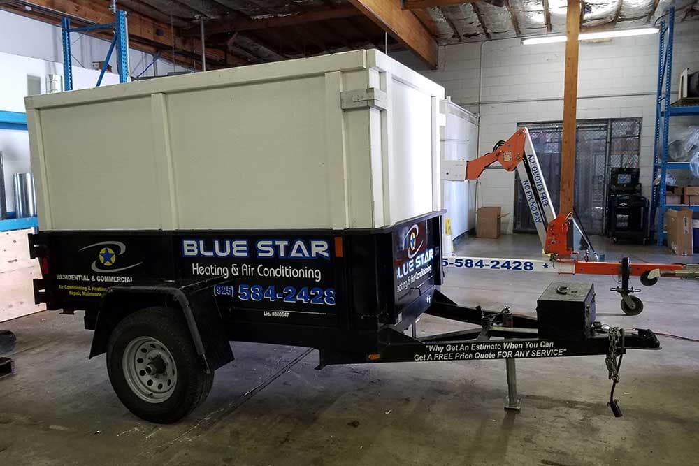 Joe Jr, Blue Star's black dump trailer with raised white sides, parked inside the Blue Star warehouse