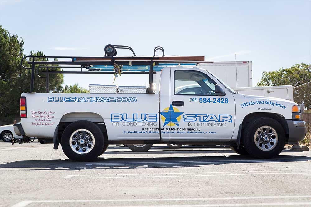Shooter, a white Blue Star GMC 1500 pickup with a rack, lettered 'You Pay No More Than Your Quote'