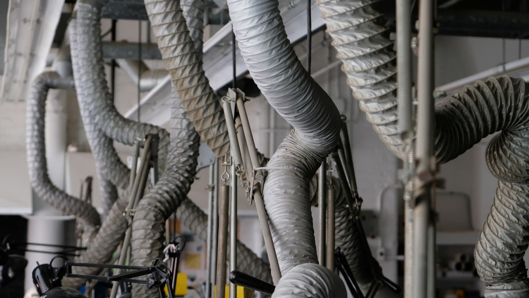 Grey flexible ducts looping down from a ceiling